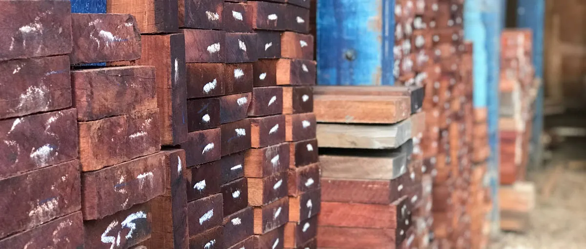 Pilhas de vigas e tábuas de madeira no pátio da Madeireira Wood Fort